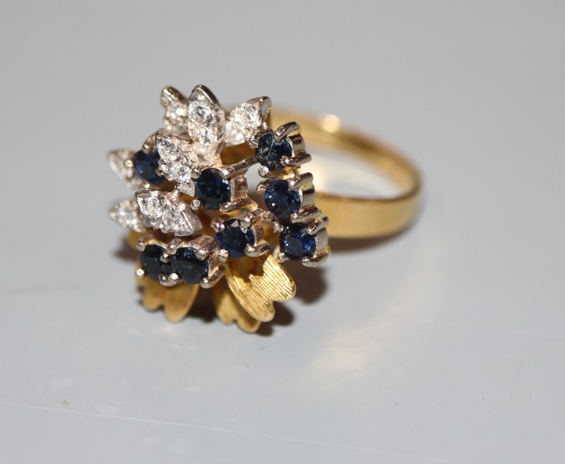 A modern 18ct gold, sapphire and diamond raised cluster dress ring, size N, gross 7.4 grams.